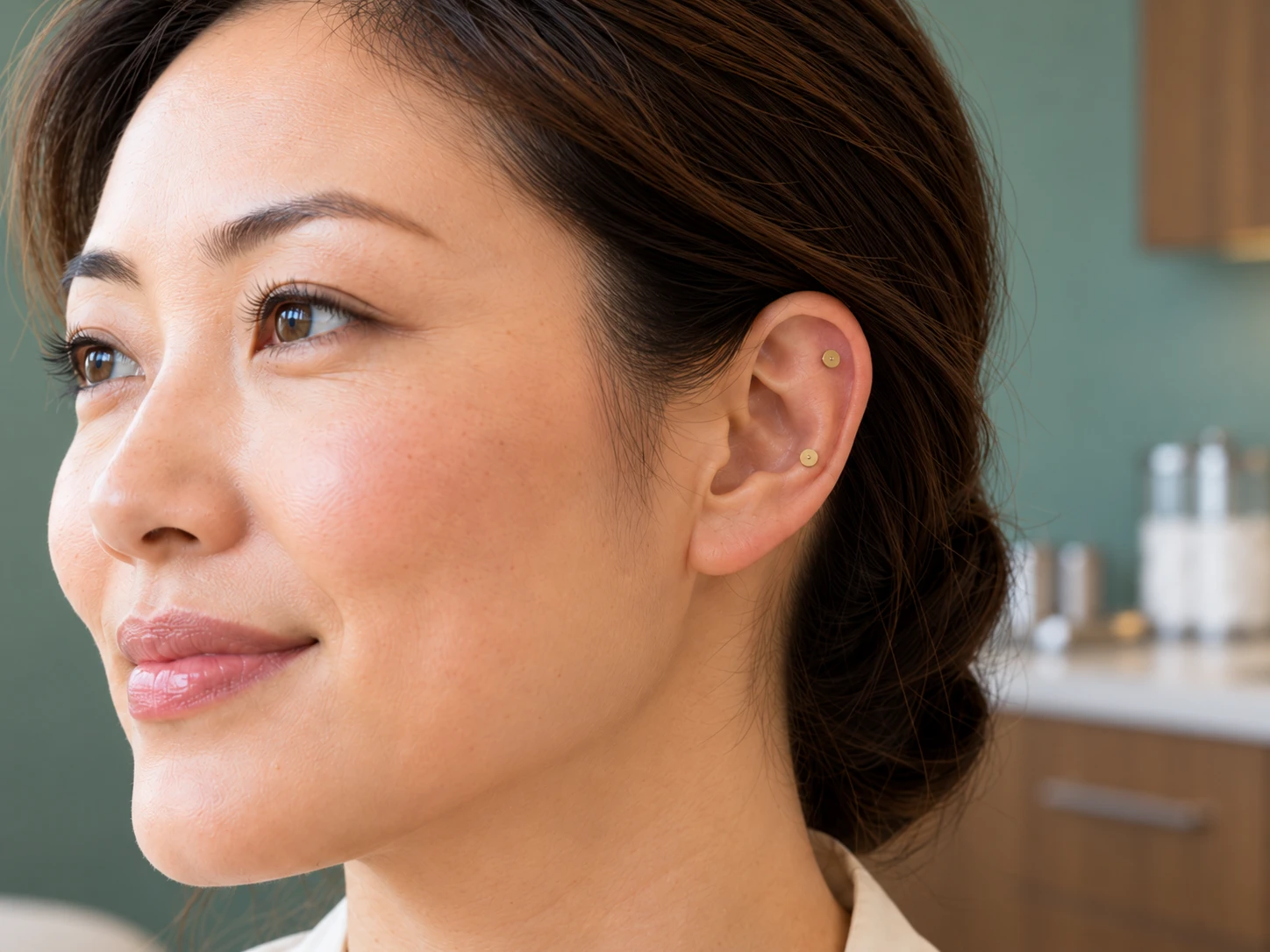 Same woman with an illustrative view of small metallic ASP auricular needle heads